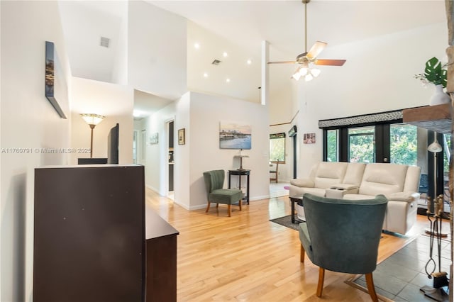 living area featuring light wood finished floors, visible vents, baseboards, and ceiling fan