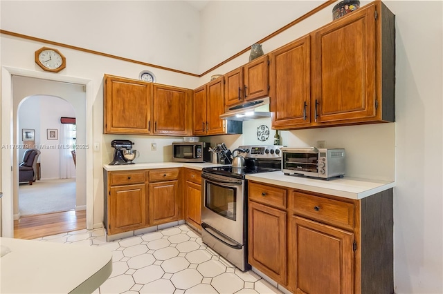 kitchen featuring under cabinet range hood, appliances with stainless steel finishes, light countertops, and a toaster