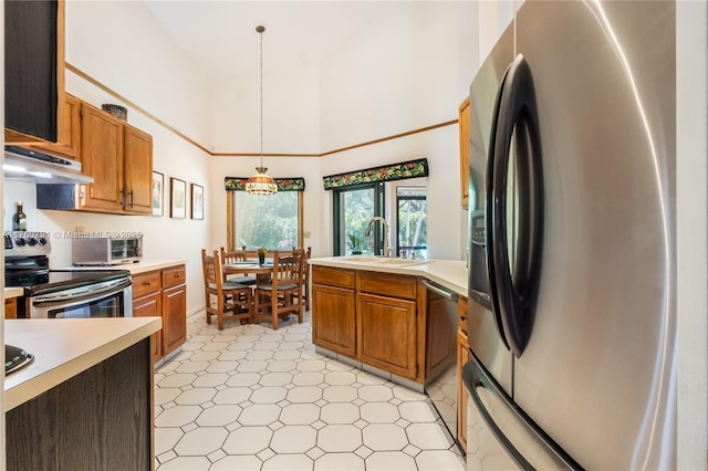 kitchen featuring under cabinet range hood, brown cabinets, appliances with stainless steel finishes, and light countertops