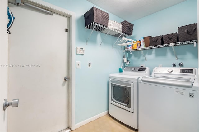 laundry area featuring baseboards, separate washer and dryer, and laundry area