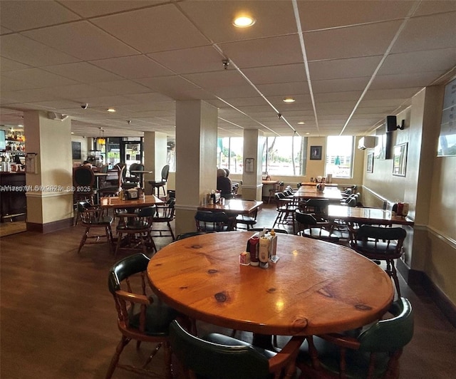 dining room with wood finished floors, a paneled ceiling, and baseboards