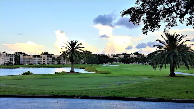 view of community featuring a yard, a water view, and golf course view