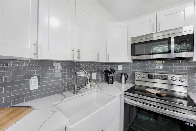 1 Keswick A 1, Deerfield Beach, FL 33442 - kitchen featuring stainless steel appliances, a sink, backsplash, white cabinetry, and light stone countertops