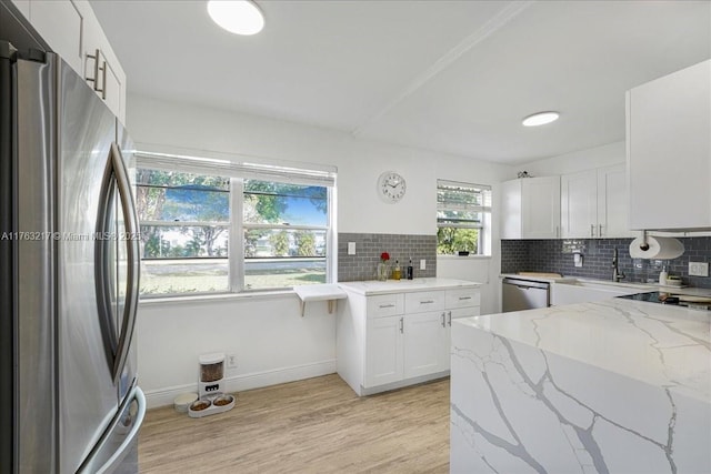 1 Keswick A 1, Deerfield Beach, FL 33442 - kitchen with appliances with stainless steel finishes, light wood-style flooring, light stone counters, tasteful backsplash, and white cabinetry