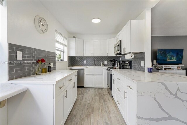 1 Keswick A 1, Deerfield Beach, FL 33442 - kitchen featuring stainless steel appliances, light wood-style flooring, light stone counters, and white cabinets