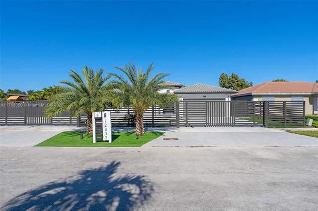 exterior space featuring a gate, a fenced front yard, and a tiled roof