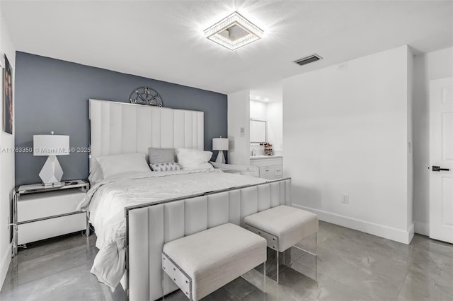 bedroom with baseboards, visible vents, and ensuite bath