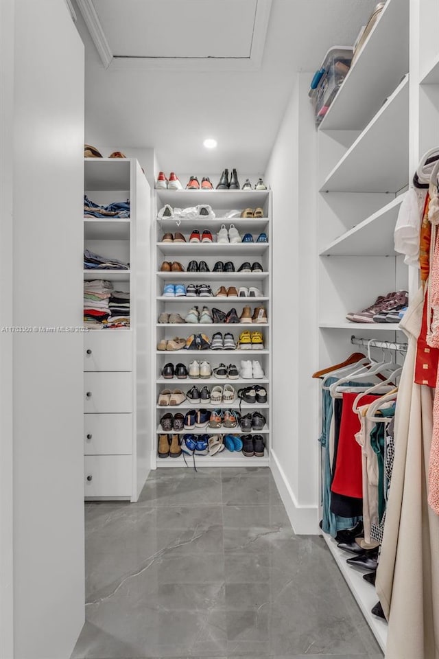 walk in closet featuring marble finish floor