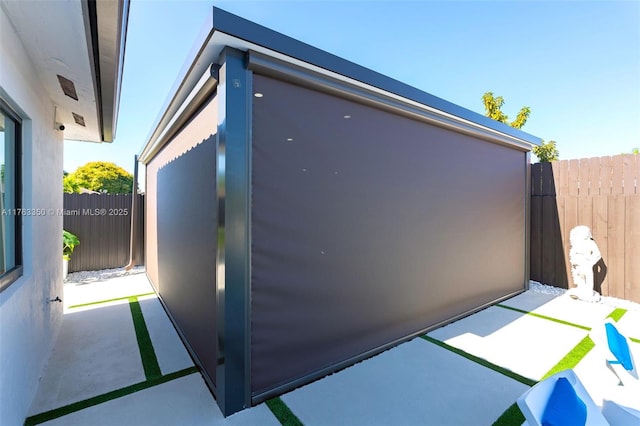 exterior space featuring a patio, fence, and stucco siding