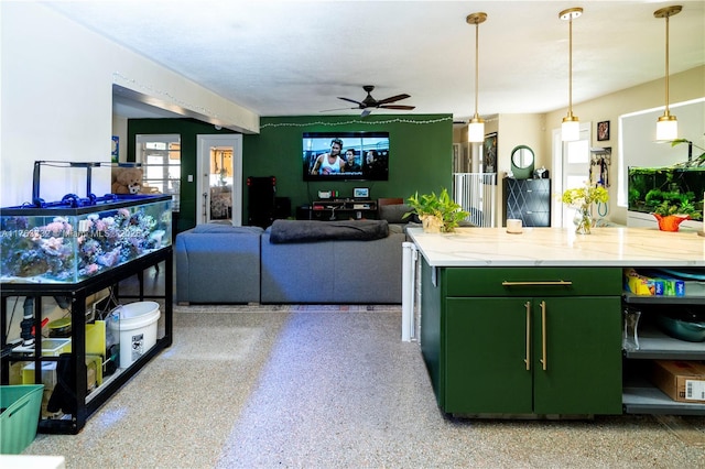 kitchen with ceiling fan, open floor plan, hanging light fixtures, light speckled floor, and green cabinetry