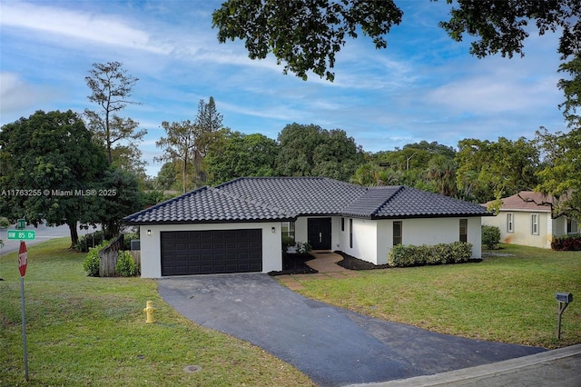 ranch-style home featuring stucco siding, driveway, a front yard, and a garage