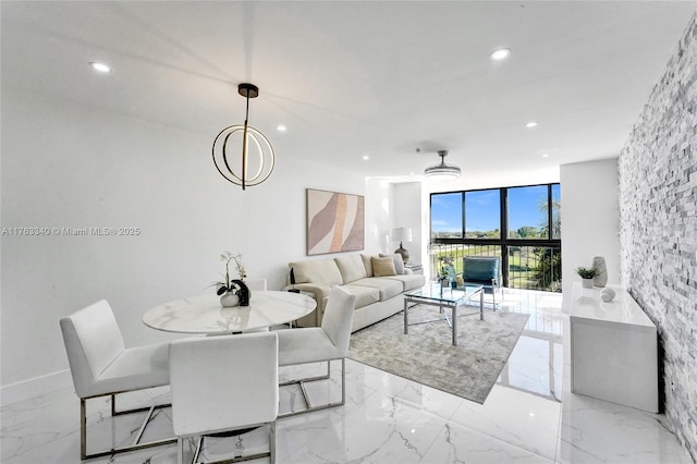 living room with floor to ceiling windows, recessed lighting, and marble finish floor