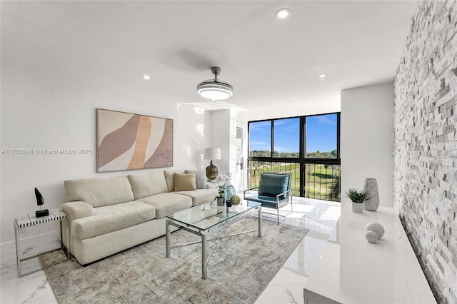 living room featuring recessed lighting, marble finish floor, and a wall of windows