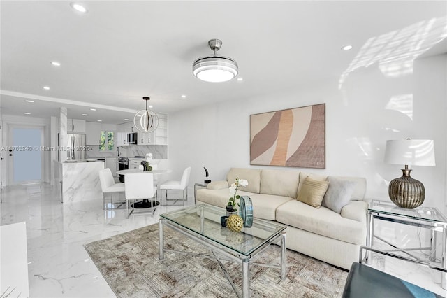 living area with recessed lighting and marble finish floor