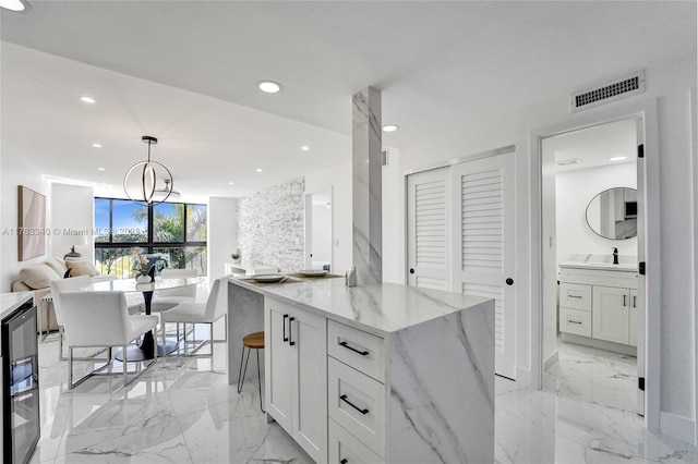 kitchen with open floor plan, recessed lighting, visible vents, and marble finish floor