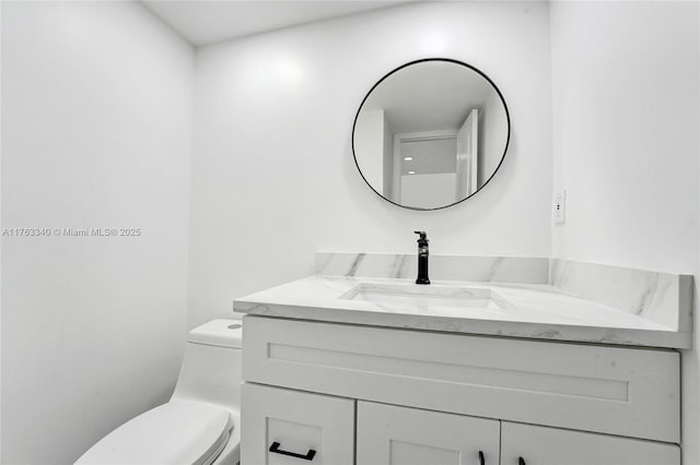 half bathroom with vanity and toilet