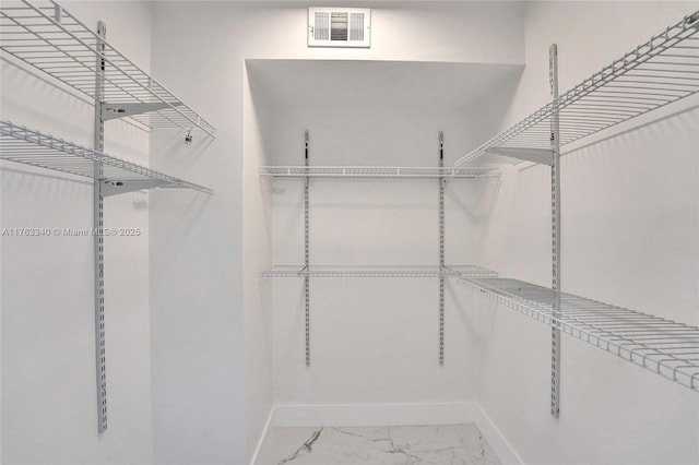 walk in closet featuring visible vents and marble finish floor