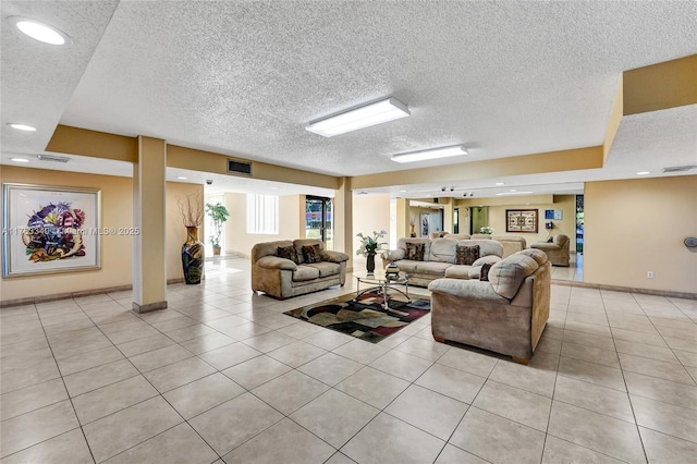 living room featuring light tile patterned flooring, visible vents, recessed lighting, and a textured ceiling