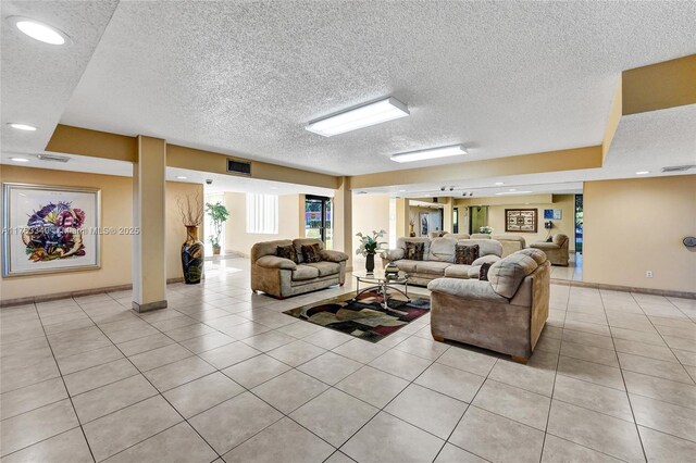 living area featuring light tile patterned floors, baseboards, recessed lighting, and a textured ceiling
