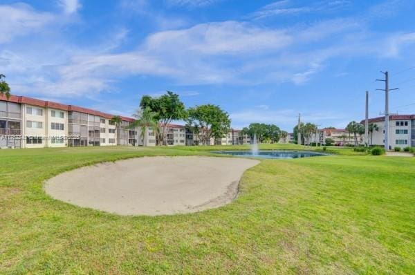 view of property's community featuring a yard and a water view