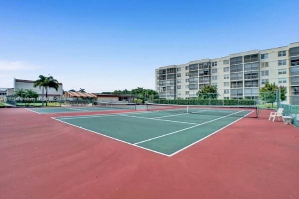view of tennis court featuring fence and community basketball court