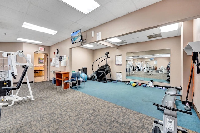 gym featuring carpet flooring, a drop ceiling, and baseboards