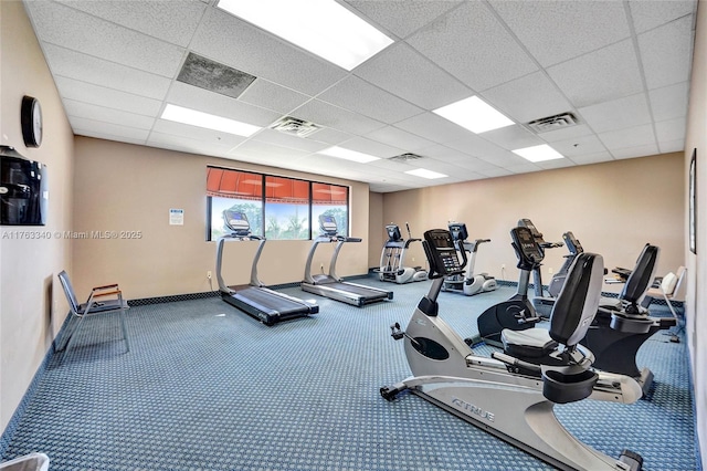 exercise room with a drop ceiling, baseboards, and carpet flooring