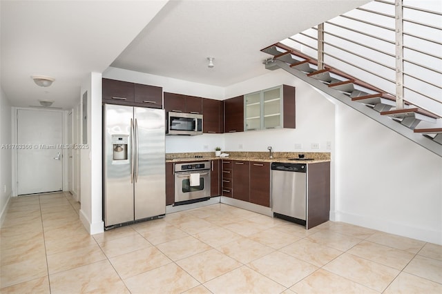 41 SE 5th St Unit 1815, Miami, FL 33131 - kitchen featuring stainless steel appliances, dark brown cabinets, glass insert cabinets, light stone countertops, and light tile patterned floors