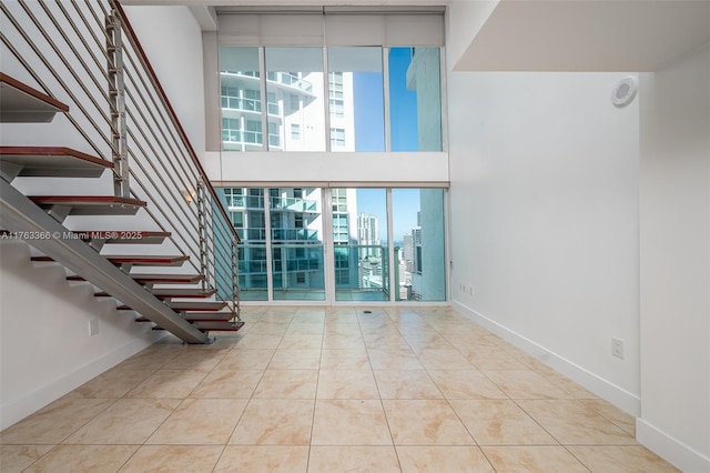 41 SE 5th St Unit 1815, Miami, FL 33131 - tiled spare room with a towering ceiling, stairs, and baseboards