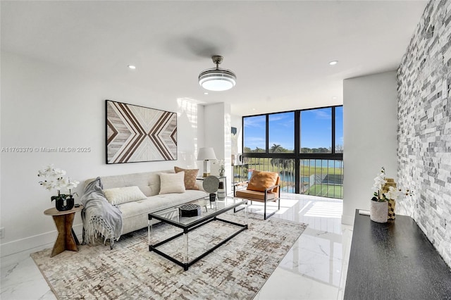 living room featuring recessed lighting, baseboards, marble finish floor, and floor to ceiling windows