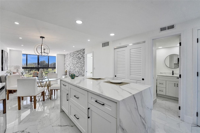 kitchen with visible vents, light stone counters, recessed lighting, marble finish floor, and white cabinetry