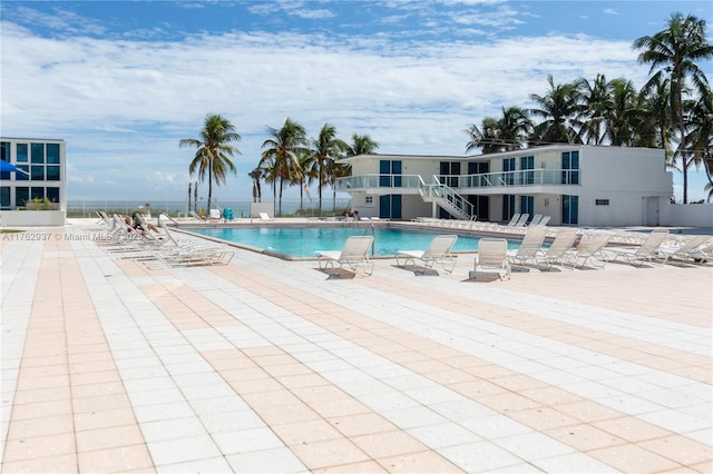 community pool with stairs and a patio area