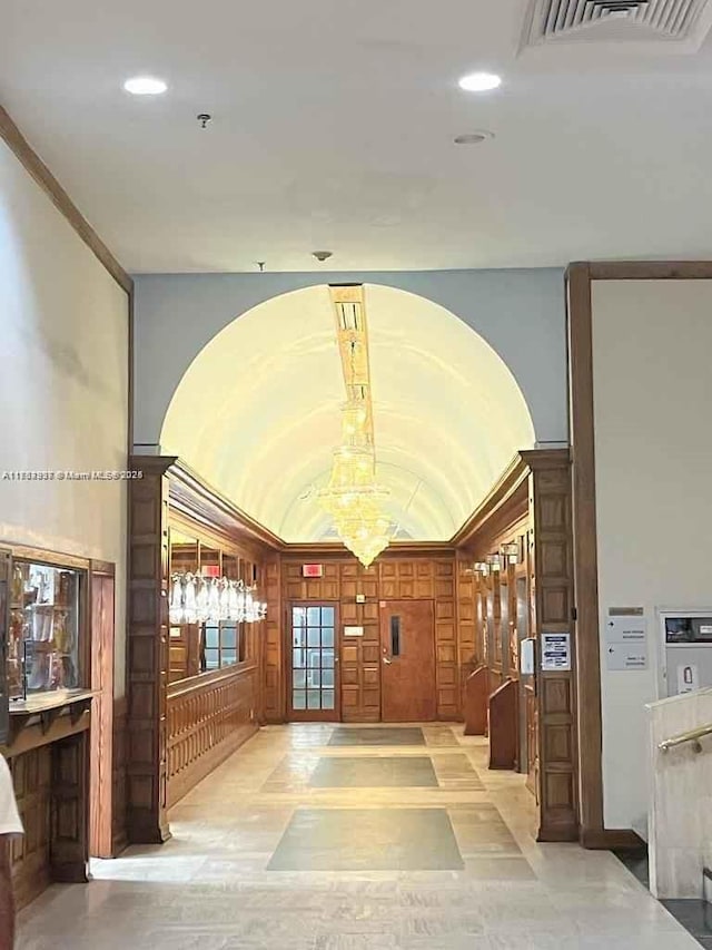 corridor featuring lofted ceiling, recessed lighting, and visible vents