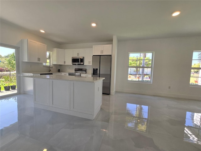 kitchen featuring light countertops, white cabinets, a healthy amount of sunlight, and appliances with stainless steel finishes