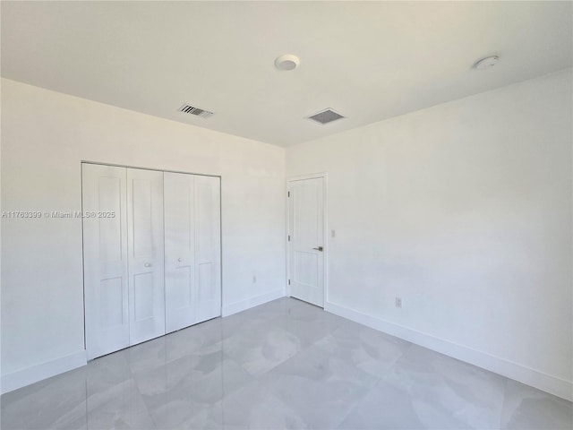 unfurnished bedroom with visible vents, baseboards, and a closet