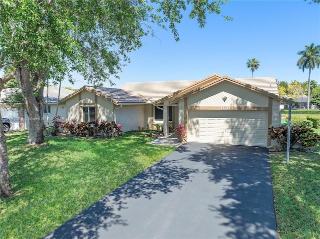 ranch-style home with brick siding, aphalt driveway, a front lawn, and an attached garage