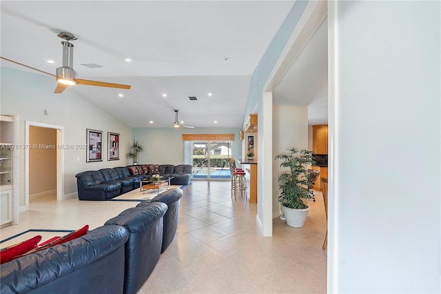 living room featuring light tile patterned flooring, visible vents, lofted ceiling, and a ceiling fan