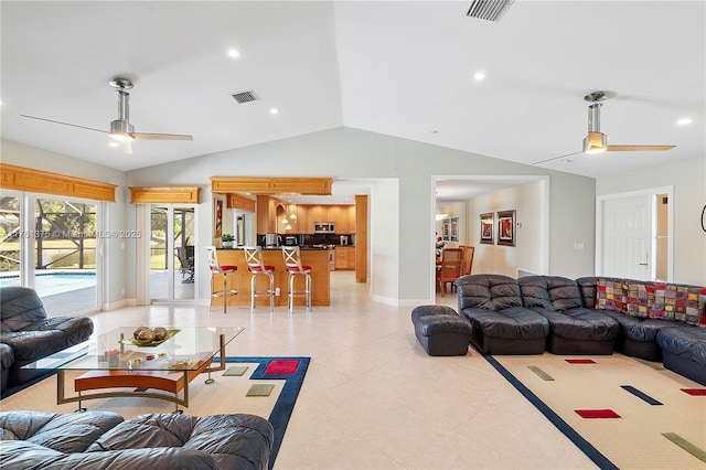 living room featuring lofted ceiling, light tile patterned flooring, a ceiling fan, and visible vents