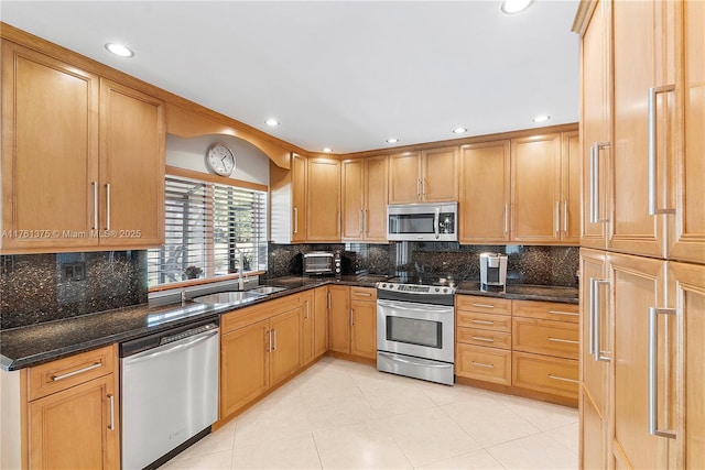 kitchen featuring backsplash, appliances with stainless steel finishes, and a sink