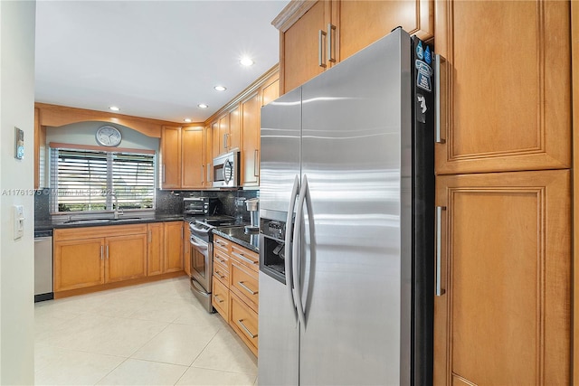 kitchen featuring a sink, tasteful backsplash, recessed lighting, appliances with stainless steel finishes, and light tile patterned floors