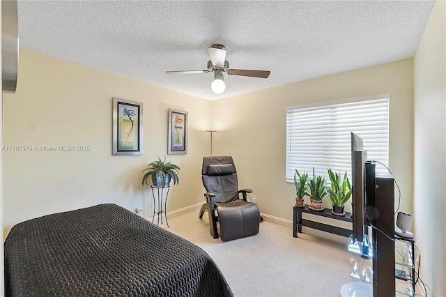 carpeted bedroom featuring baseboards, a textured ceiling, and ceiling fan