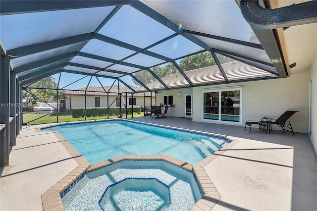 view of swimming pool featuring a patio area, glass enclosure, and a pool with connected hot tub