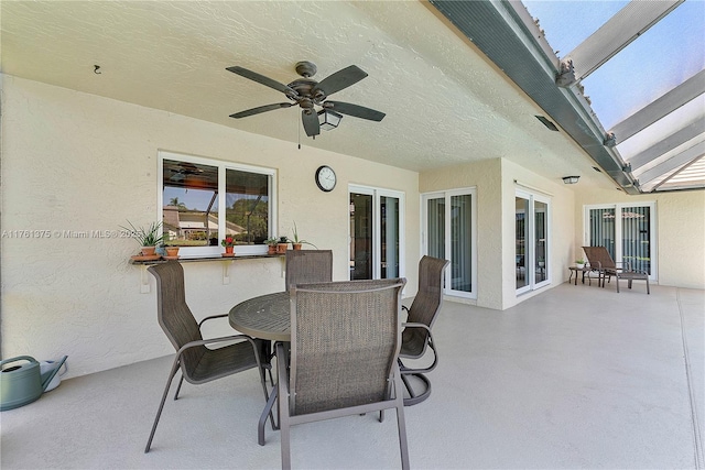 view of patio / terrace with a lanai, outdoor dining area, and ceiling fan