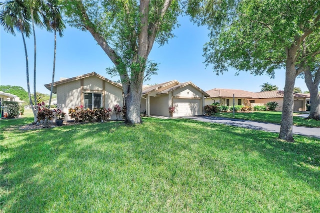 ranch-style house with aphalt driveway, an attached garage, and a front yard