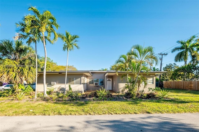 single story home featuring a front lawn, fence, and stucco siding