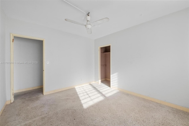 unfurnished bedroom featuring speckled floor, baseboards, a closet, and ceiling fan