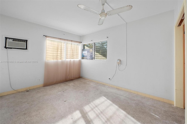 carpeted empty room featuring an AC wall unit, baseboards, and ceiling fan