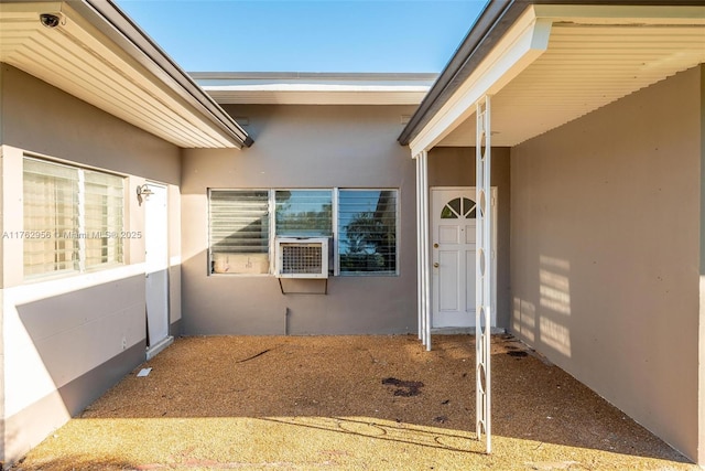 property entrance with cooling unit and stucco siding