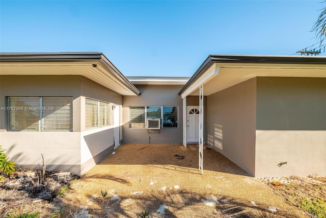 exterior space with stucco siding and cooling unit