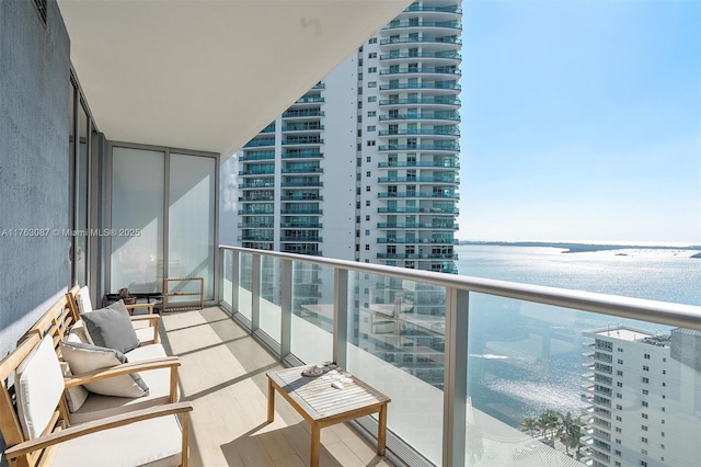 balcony with a water view and a view of city